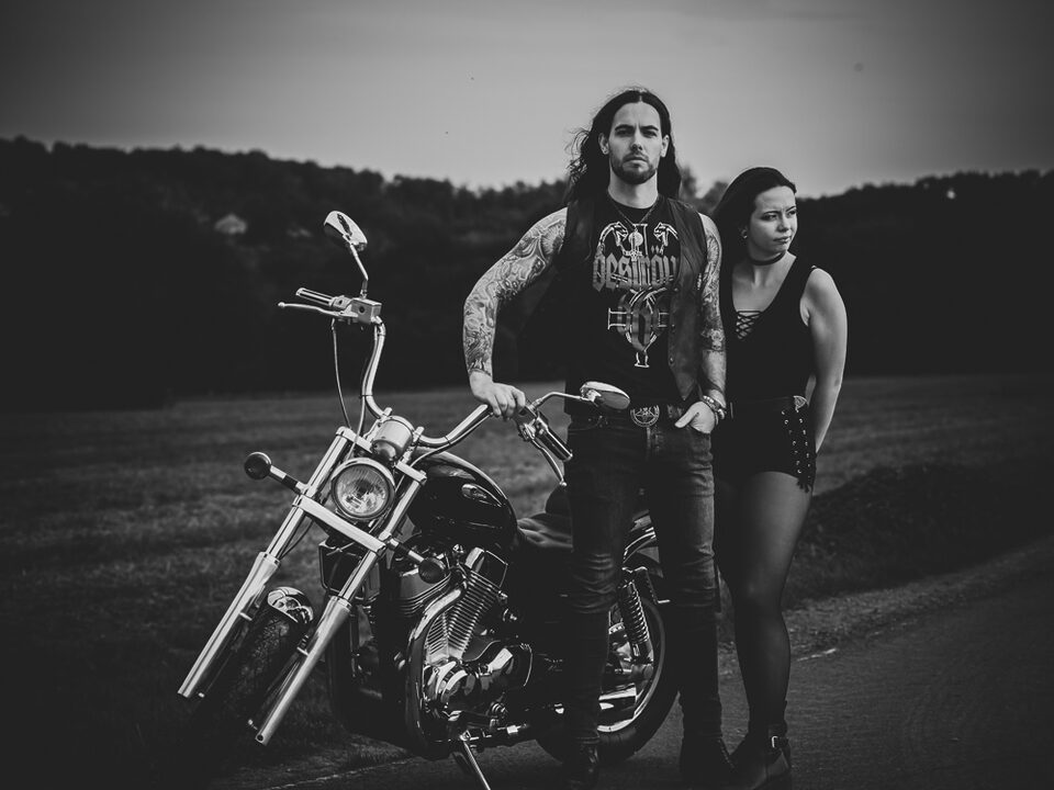 Tätowiertes Hochzeitspaar mit Motorrad vor dunkler Kulisse – Metal Me inszeniert den Spirit einer Metal Hochzeit und zeigt, wie schön alternativ Heiraten sein kann