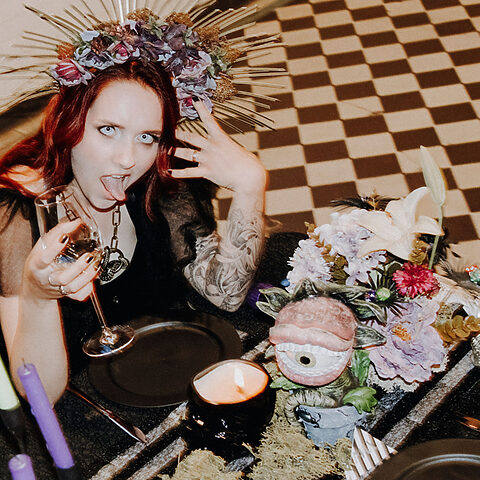 Braut mit rotem Haar und schwarzem Kleid bei einer Halloween Hochzeit mit Gothic Dekoration