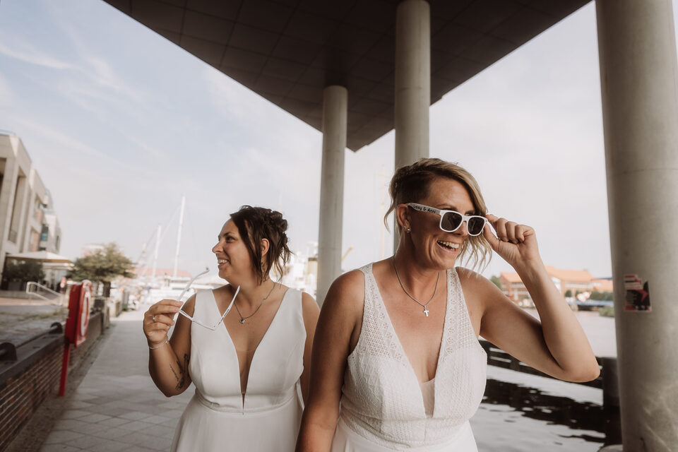 Sonnenbrillen an, Welt aus: zwei Bräute am Wasser – candid Hochzeitsfoto von Patricia Bakker.