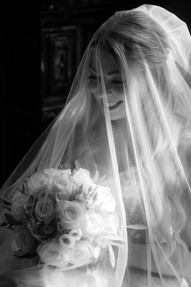 Schleier, Rosenstrauß, dieses „Okay, jetzt wird’s echt“-Lächeln – Getting Ready in Schwarzweiß, fotografiert von Patricia Bakker.