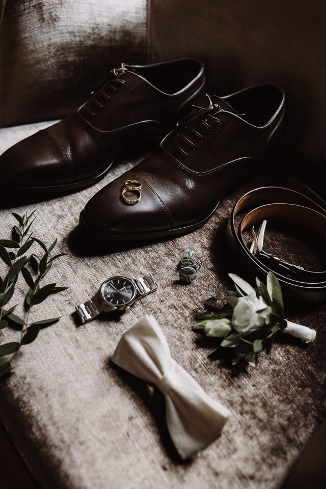 Flatlay fürs Styling-Board: Schuhe, Ringe, Uhr, Gürtel, Manschettenknöpfe und Fliege – Detailfoto von Patricia Bakker.
