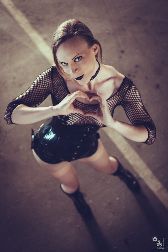 Verena Rau im Gothic-Outfit formt mit den Händen ein Herz